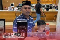 Foto. Warga Sumenep, Toifur Ali Wafa saat Melakukan Tukar Tambah Handphone untuk Anak Pertamanya. 